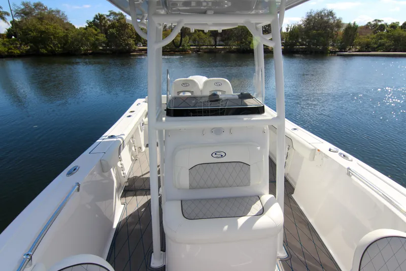Slide: The Image of 2018 Sportsman Heritage 241 Center Console boat on calm water, featuring sleek design and spacious deck. - 22