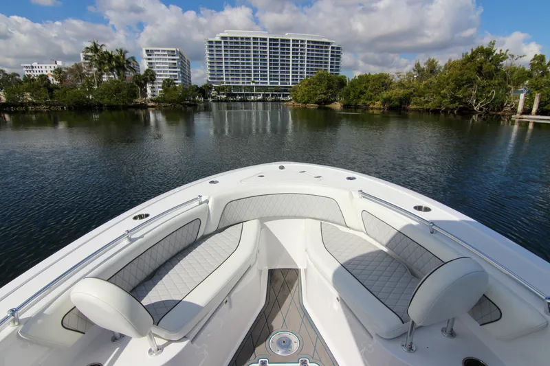 Slide: The Image of 2018 Sportsman Heritage 241 Center Console boat on calm water with cityscape background. - 26