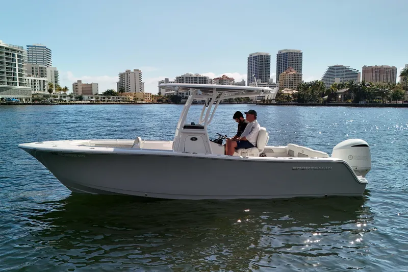 Slide: The Image of 2018 Sportsman Heritage 241 Center Console boat on water with city skyline backdrop. - 3