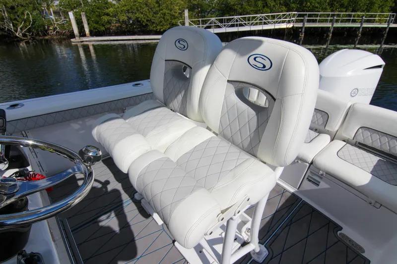 Slide: The Image of 2018 Sportsman Heritage 241 Center Console boat with luxurious white seating and steering wheel. - 31