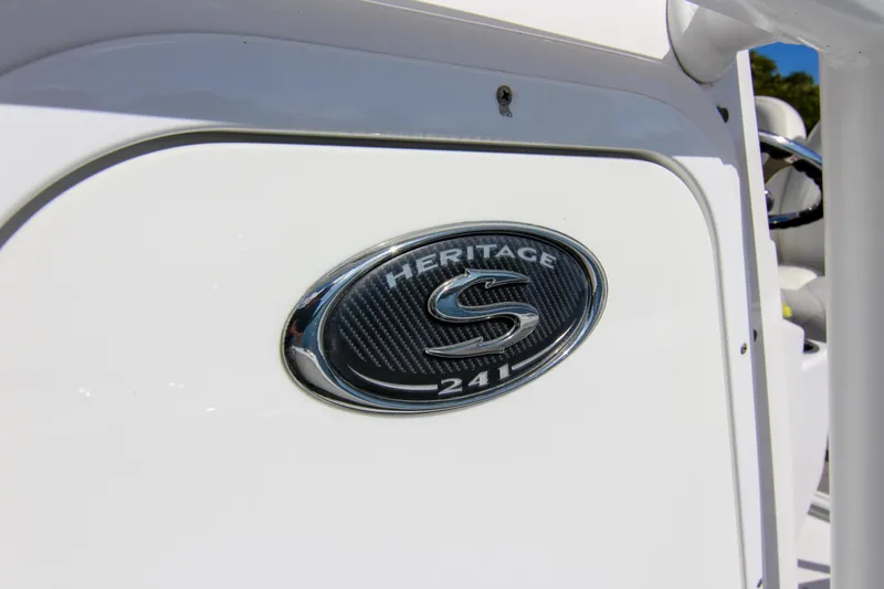 Slide: The Image of 2018 Sportsman Heritage 241 Center Console emblem on white boat exterior. - 36