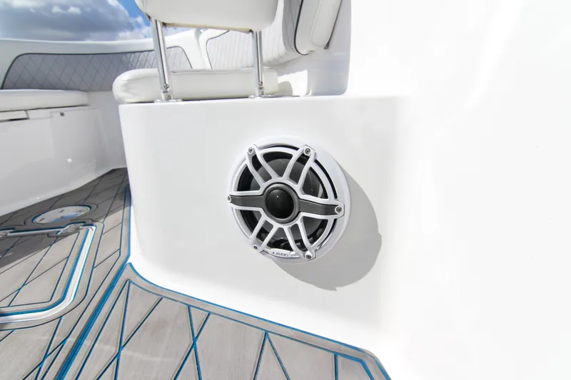 Slide: The Image of 2018 Sportsman Heritage 241 Center Console boat interior with speaker and cushioned seating. - 38