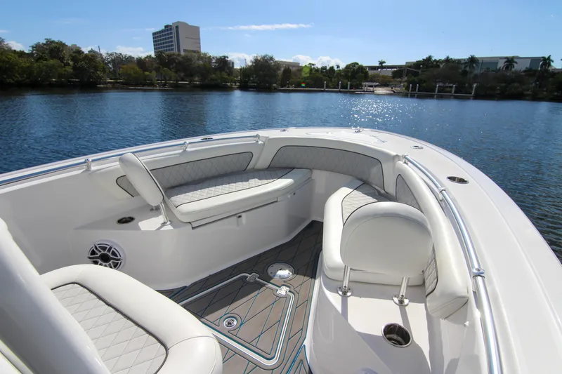 Slide: The Image of 2018 Sportsman Heritage 241 Center Console boat interior with cushioned seating on a sunny day. - 39