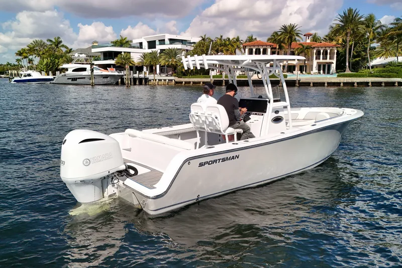 Slide: The Image of 2018 Sportsman Heritage 241 Center Console boat cruising on a sunny day near luxury waterfront homes. - 4