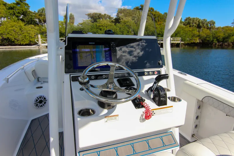 Slide: The Image of 2018 Sportsman Heritage 241 Center Console boat dashboard with steering wheel and navigation system. - 42