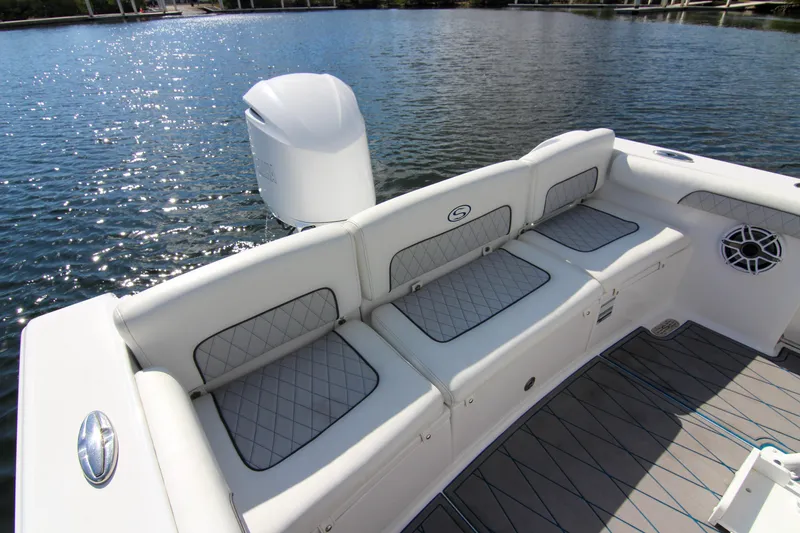 Slide: The Image of 2018 Sportsman Heritage 241 Center Console boat with cushioned seating on calm water. - 46