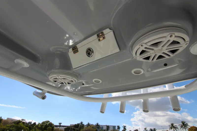 Slide: The Image of 2018 Sportsman Heritage 241 Center Console boat speakers and rod holders under blue sky. - 48