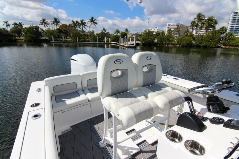 Slide: The Image of 2018 Sportsman Heritage 241 Center Console boat interior with plush seating and steering wheel. - 49