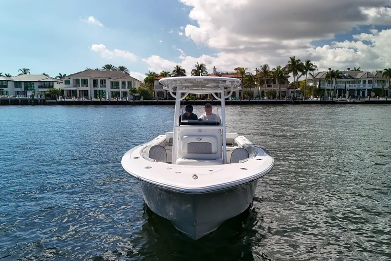 Slide: The Image of 2018 Sportsman Heritage 241 Center Console boat on water near waterfront homes. - 5
