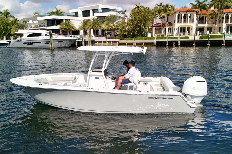 Slide: The Image of 2018 Sportsman Heritage 241 Center Console boat on water near luxury waterfront homes. - 8