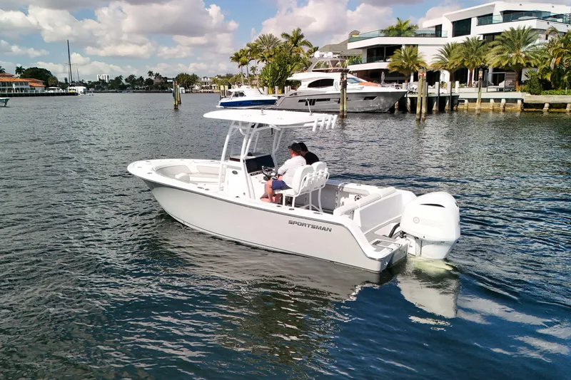 Slide: The Image of 2018 Sportsman Heritage 241 Center Console boat cruising near waterfront homes. - 9