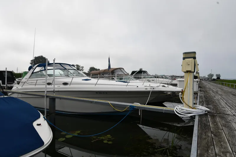 The Image of 1995 Sea Ray 330 Sundancer docked at a marina on a cloudy day. - 0