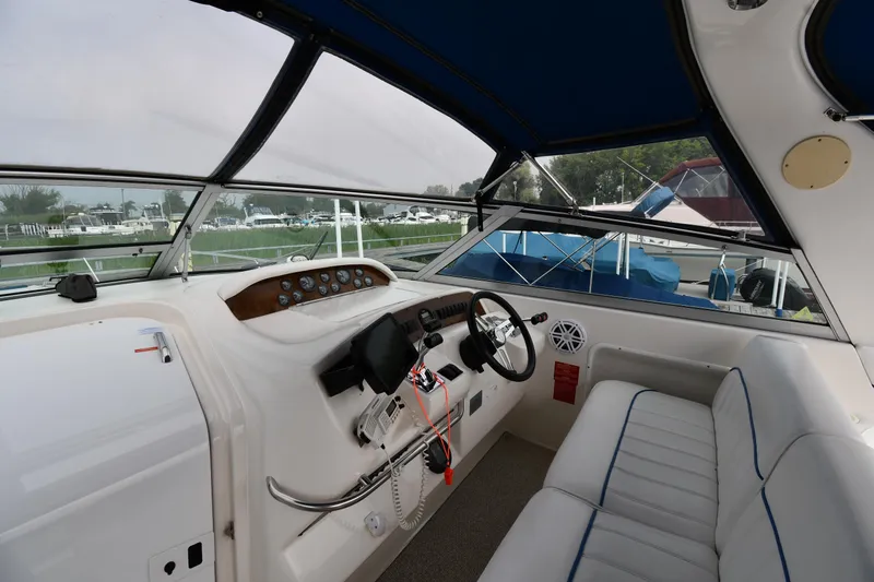 Slide: The Image of Interior view of a 1995 Sea Ray 330 Sundancer boat cockpit with steering wheel and seating. - 10