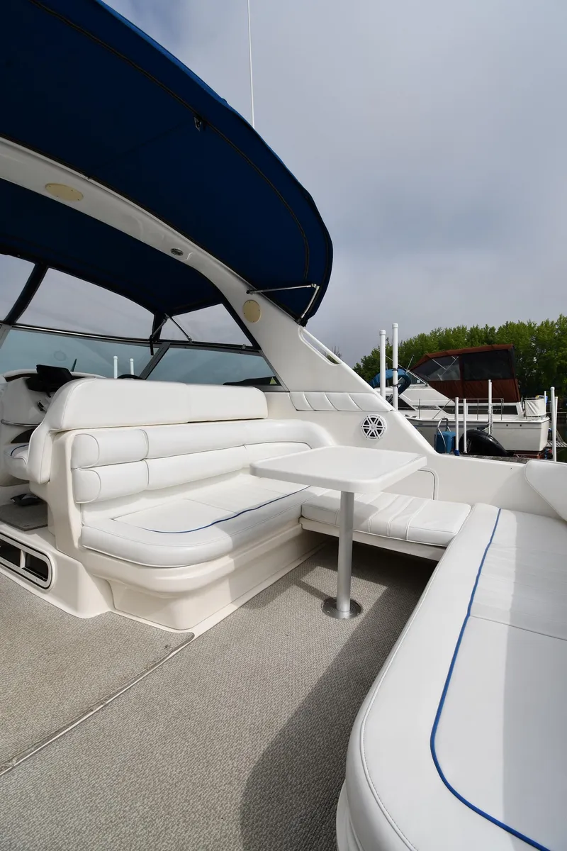Slide: The Image of 1995 Sea Ray 330 Sundancer boat interior with white seating and blue canopy. - 20
