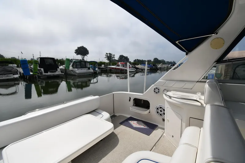 Slide: The Image of 1995 Sea Ray 330 Sundancer interior with marina view, featuring seating and speakers. - 23