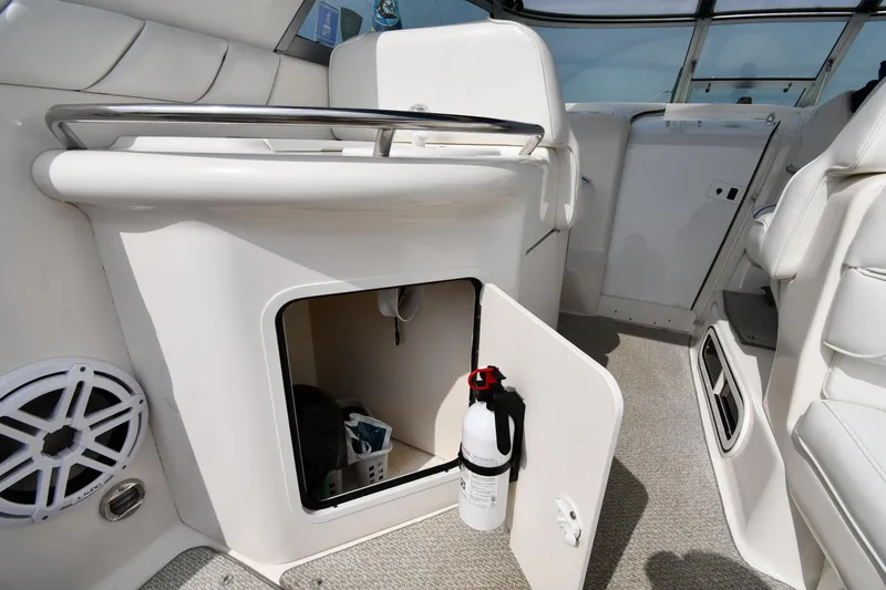 Slide: The Image of 1995 Sea Ray 330 Sundancer interior with open storage compartment and fire extinguisher. - 27
