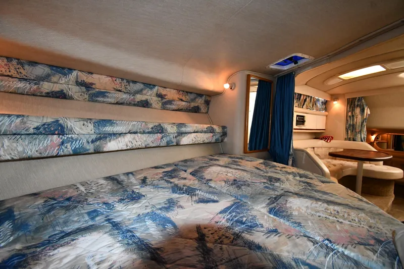 Slide: The Image of Interior of 1995 Sea Ray 330 Sundancer with patterned bedding and cozy seating area. - 35