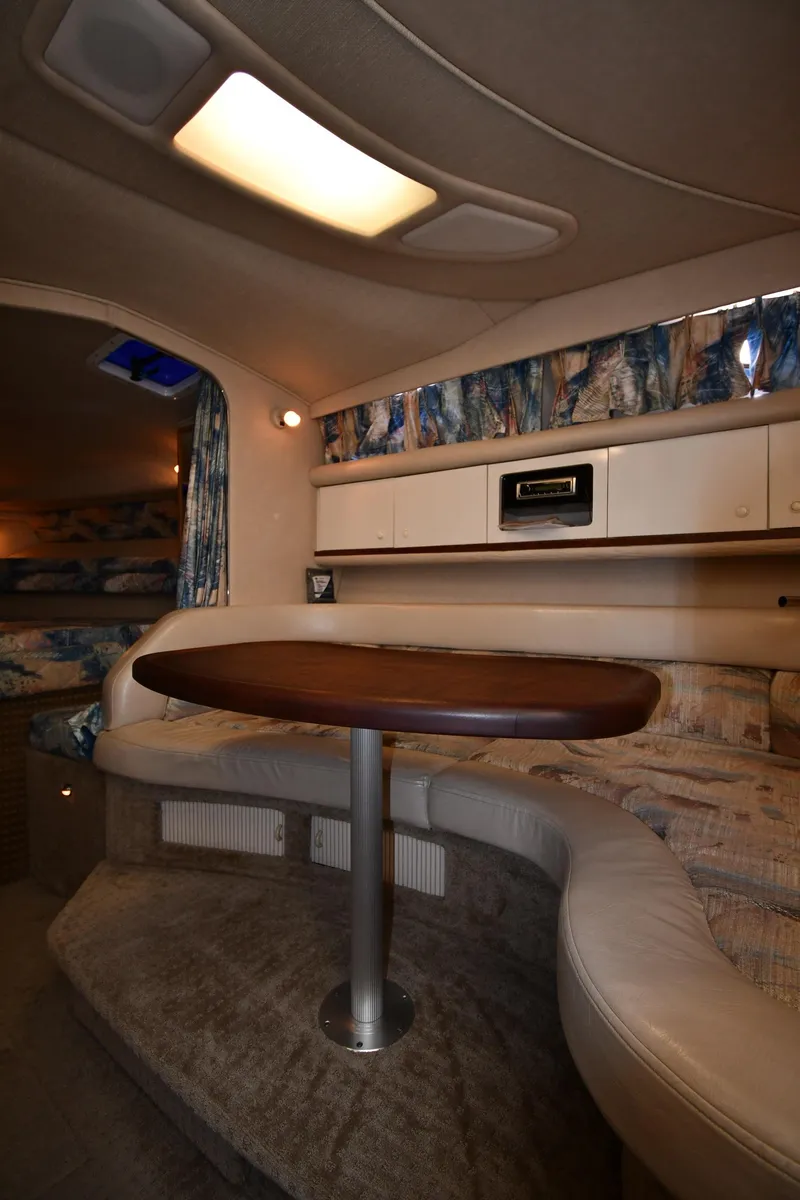 Slide: The Image of Interior of 1995 Sea Ray 330 Sundancer with cozy seating and wooden table. - 37