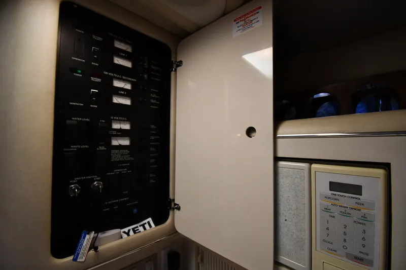 Slide: The Image of 1995 Sea Ray 330 Sundancer electrical panel and microwave controls. - 47