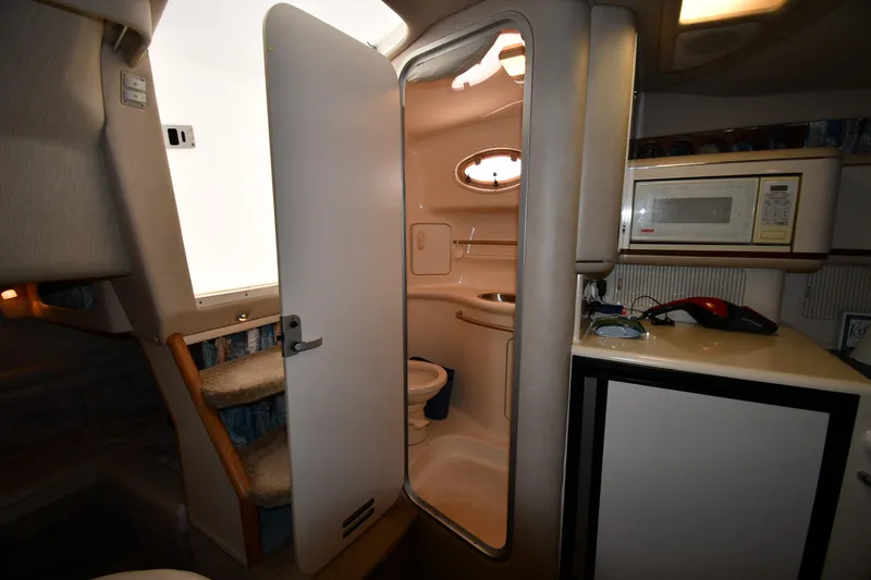 Slide: The Image of 1995 Sea Ray 330 Sundancer interior with kitchenette and bathroom. - 48