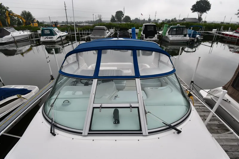 Slide: The Image of 1995 Sea Ray 330 Sundancer docked at marina, featuring blue canopy and sleek design. - 6