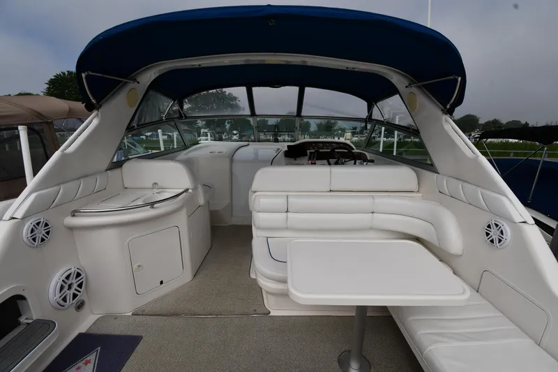 Slide: The Image of 1995 Sea Ray 330 Sundancer interior with white seating, table, and blue canopy. - 7