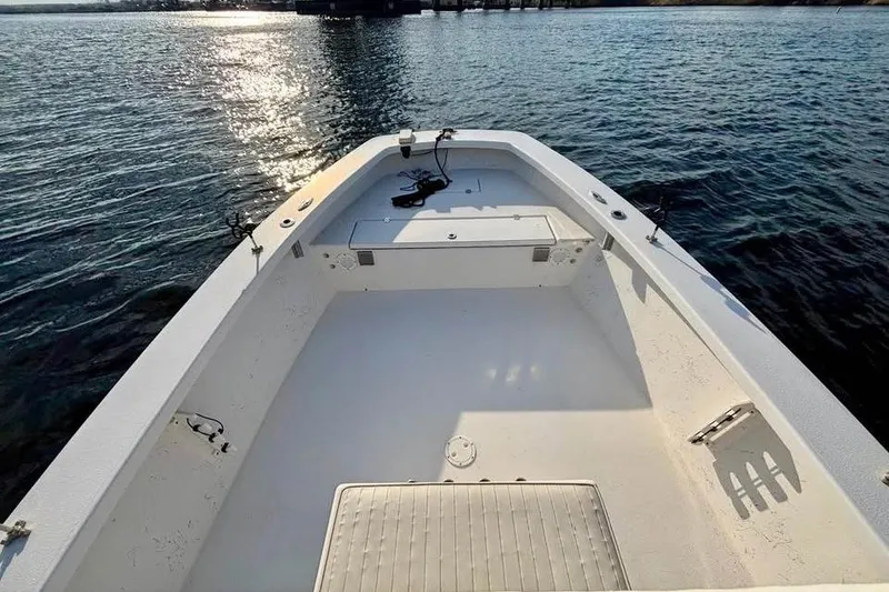 Slide: The Image of 2018 Intruder 23 boat deck on calm water, showcasing spacious interior and fishing equipment. - 10
