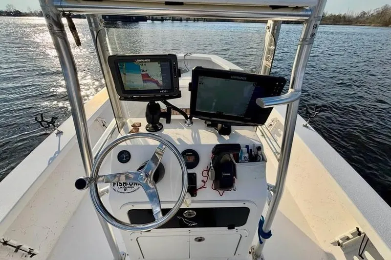 Slide: The Image of 2018 Intruder 23 boat dashboard with navigation equipment on a calm water body. - 4