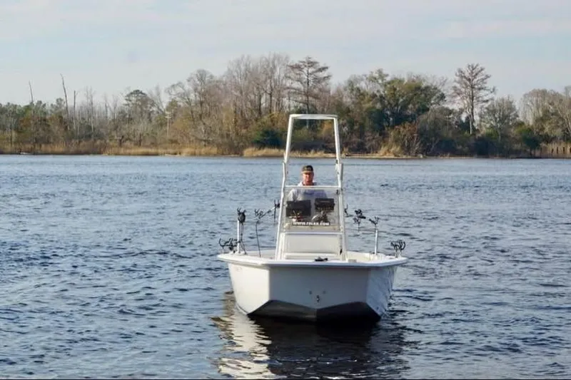 Slide: The Image of 2018 Intruder 23 boat on calm water with trees in the background. - 6
