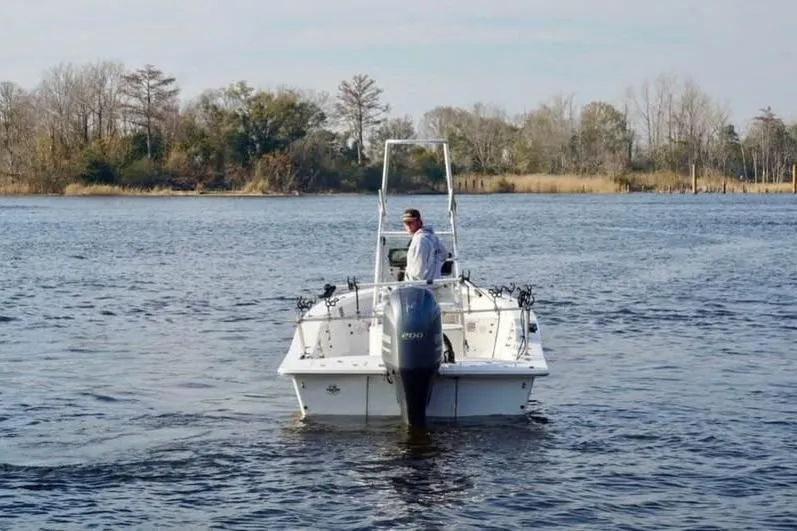 Slide: The Image of 2018 Intruder 23 boat on a calm lake with trees in the background. - 8