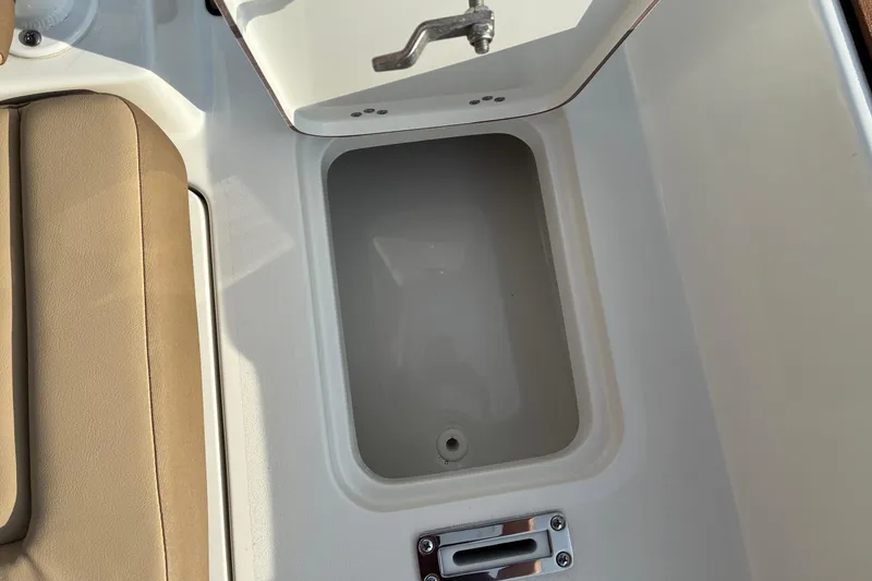 Slide: The Image of Open storage compartment on 2026 Sea Pro 245FLX Sandbar boat, featuring beige seating. - 19