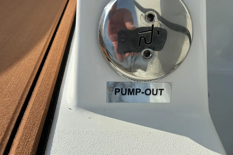 Slide: The Image of Sea Pro 245FLX Sandbar 2026 pump-out valve with reflective surface and wooden deck. - 36