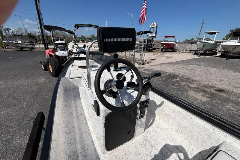 Slide: The Image of 2017 GHEENUE Super 16 boat with Humminbird system, steering wheel, and American flag in background. - 10
