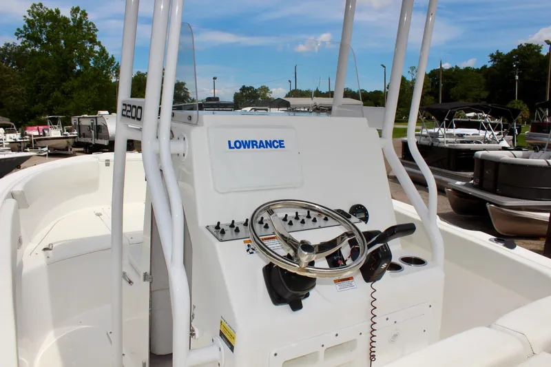 Slide: The Image of 2024 Clear Water 2200 CC boat dashboard with steering wheel and controls. - 11