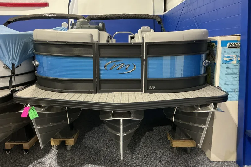The Image of 2026 Manitou Encore RF SHP575 230 pontoon boat displayed indoors. - 1