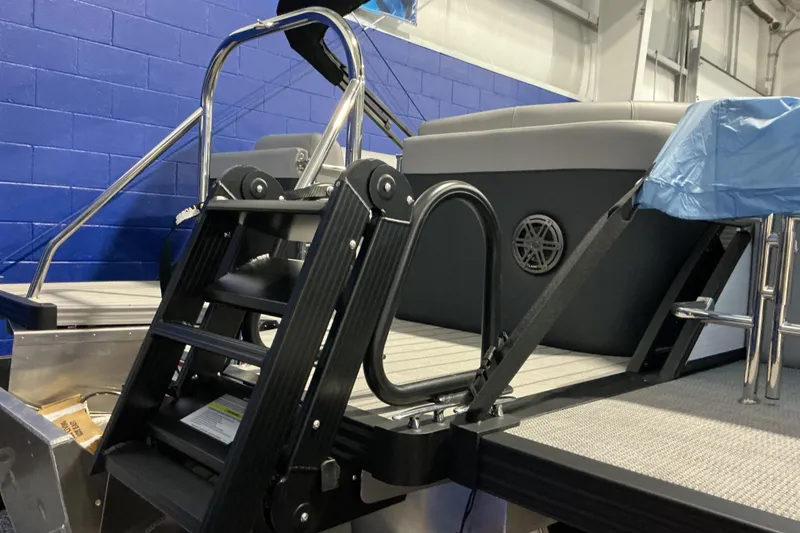 Slide: The Image of 2026 Manitou Encore RF SHP575 230 boat ladder and seating area in showroom. - 3