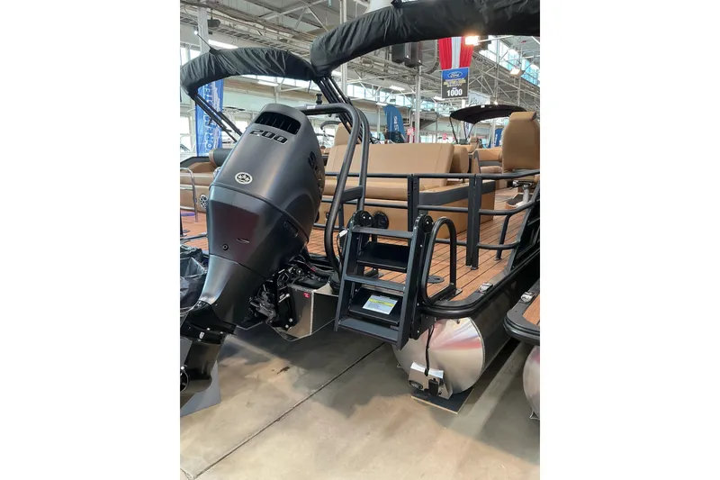 Slide: The Image of 2026 Bentley Pontoons Elite 223 Swingback Bench with powerful outboard motor in showroom. - 3