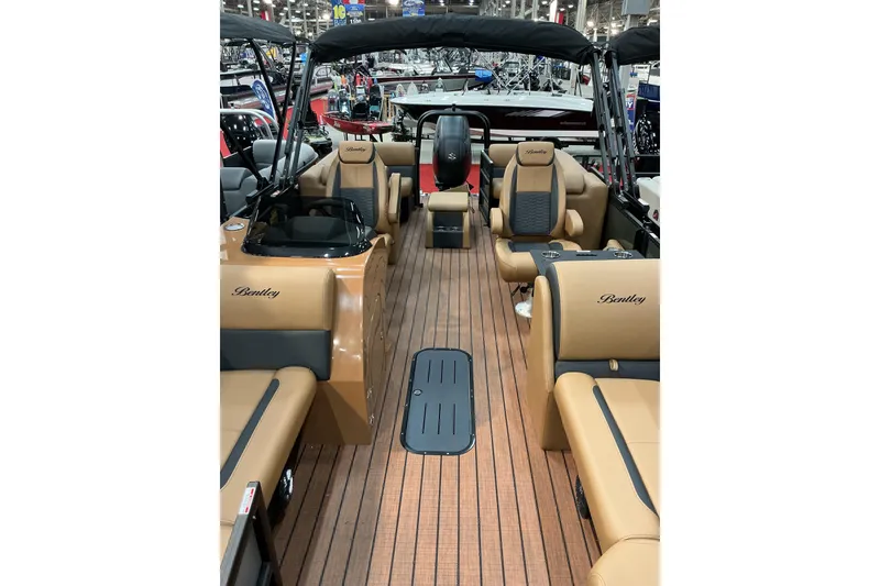 Slide: The Image of 2026 Bentley Pontoons Legacy 223 Navigator interior with tan seating and wood-style flooring. - 5