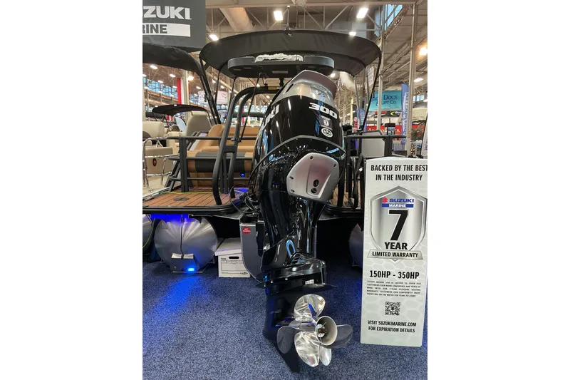 Slide: The Image of 2026 Bentley Pontoons Elite 253 with Suzuki Marine engine, showcased at a boat exhibition. - 2