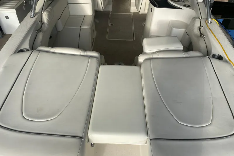Slide: The Image of 2006 Sea Ray 270 SLX boat interior with white leather seating and cup holders. - 13