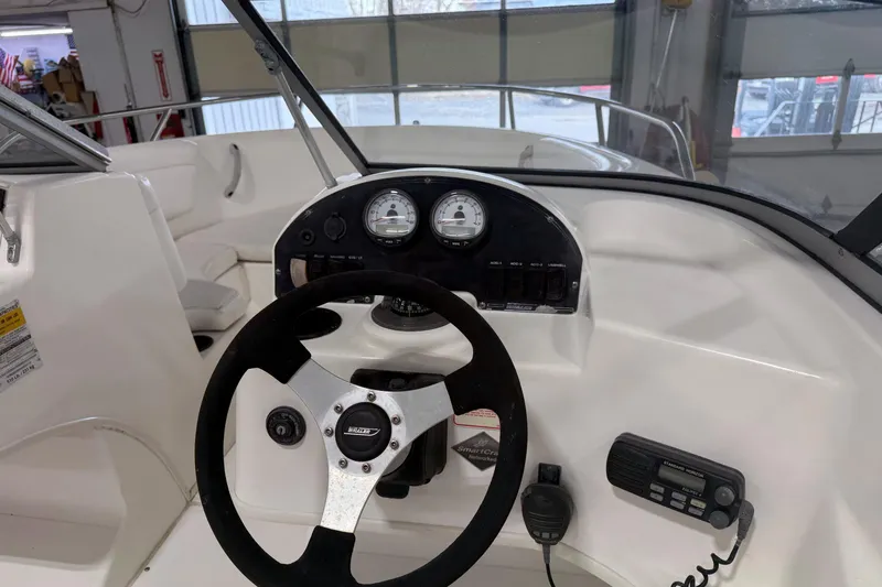 Slide: The Image of 2003 Boston Whaler 180 Ventura boat dashboard with steering wheel and control panel. - 6