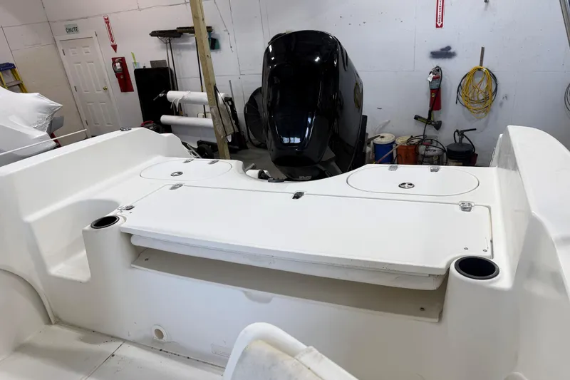 Slide: The Image of 2003 Boston Whaler 180 Ventura boat interior with engine in a workshop setting. - 7