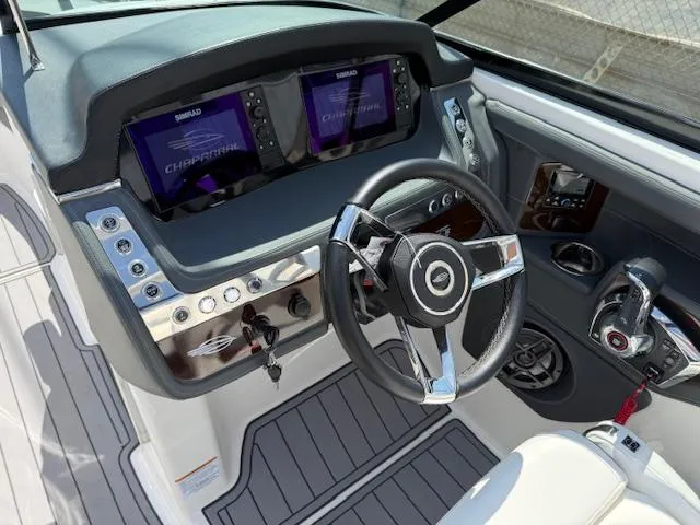 Slide: The Image of 2023 Chaparral 267 SSX boat dashboard with dual Simrad displays and sleek steering wheel. - 18