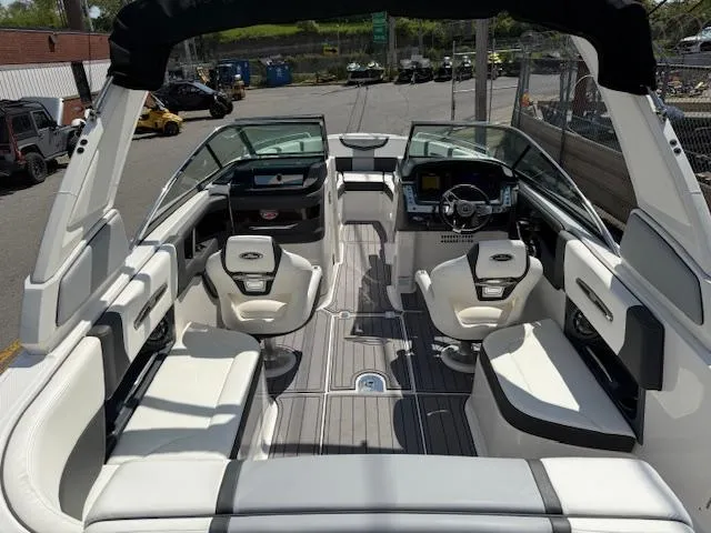 Slide: The Image of 2023 Chaparral 267 SSX boat interior with white seating and modern dashboard. - 30
