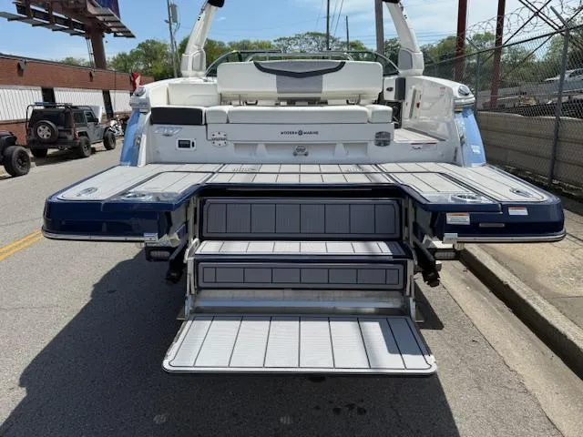 Slide: The Image of 2023 Chaparral 267 SSX boat with extended swim platform and steps, parked on street. - 34