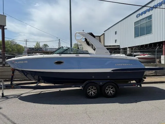 Slide: The Image of 2023 Chaparral 267 SSX boat on trailer, parked outdoors near industrial building. - 5