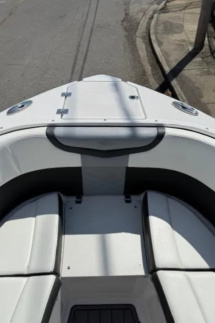 Slide: The Image of 2023 Chaparral 267 SSX boat bow with seating, parked on a street. - 9
