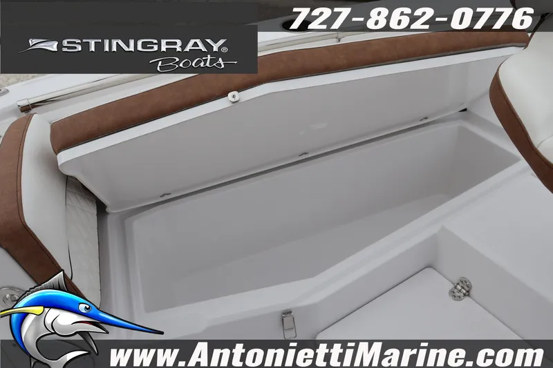 Slide: The Image of 2026 Stingray 236 CC boat interior storage compartment, featuring brown and white seating. - 33