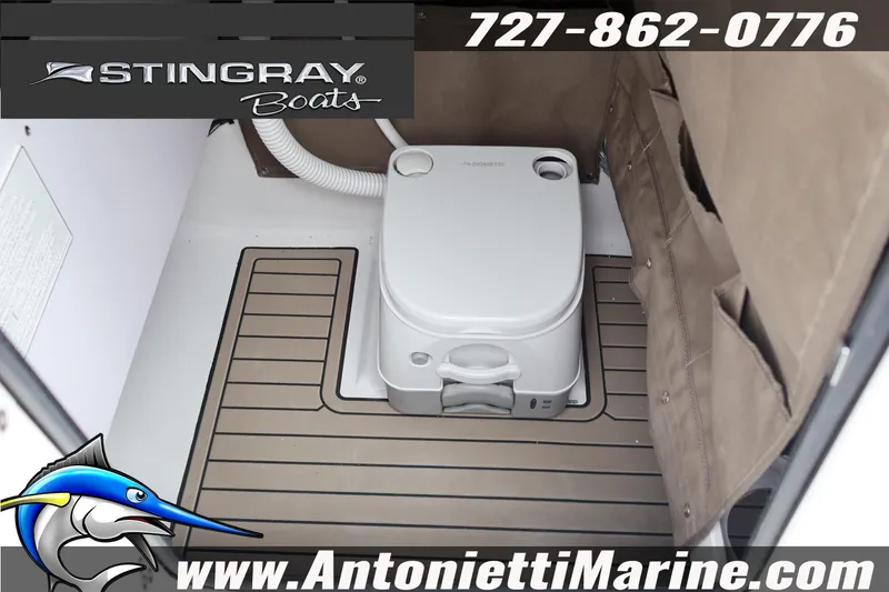 Slide: The Image of 2026 Stingray 236 CC boat interior with portable toilet, featuring marine flooring. - 37