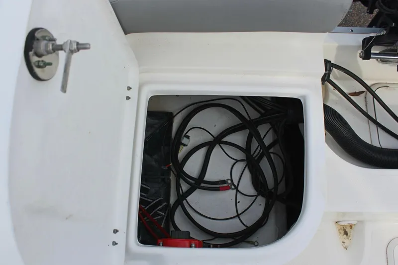 Slide: The Image of Open storage compartment with cables in a 2024 Clearwater 2200 CC boat. - 12